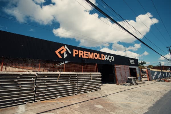 Fachada da Premoldaço com céu azul ao fundo